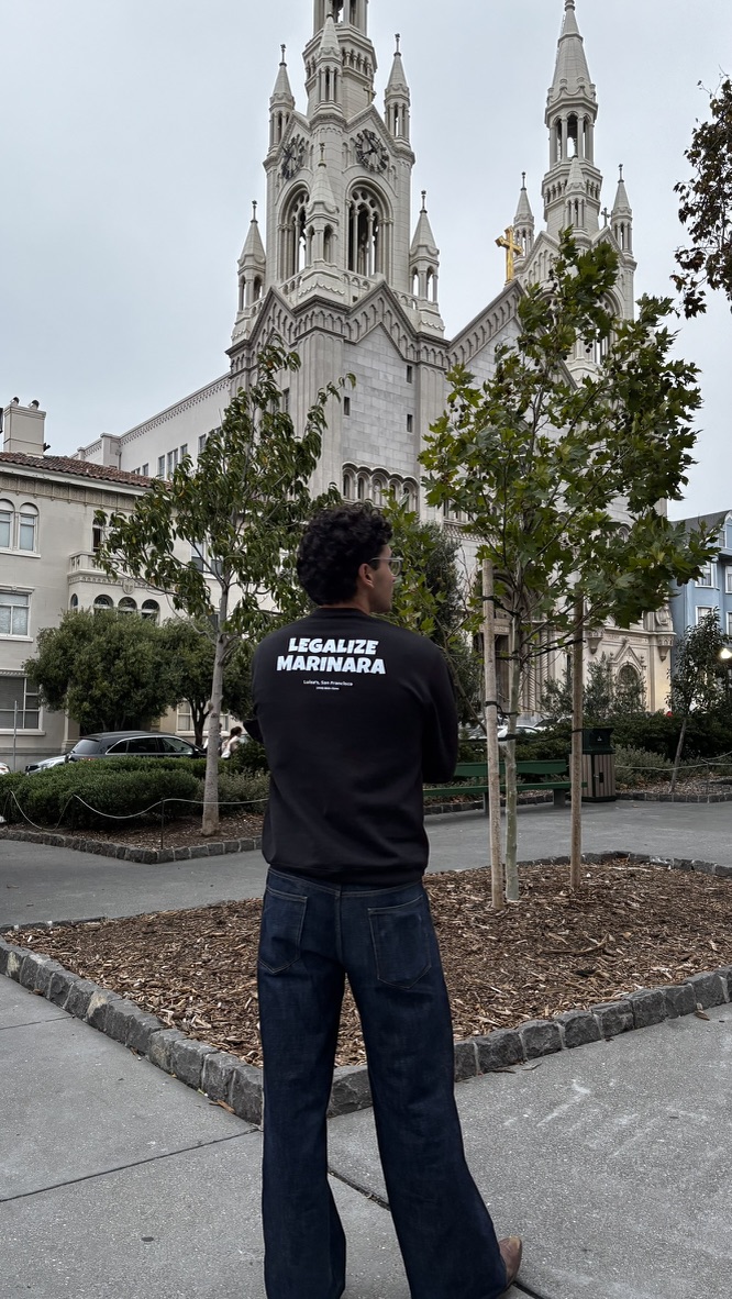 The black crewneck in front of the church on Washington Square