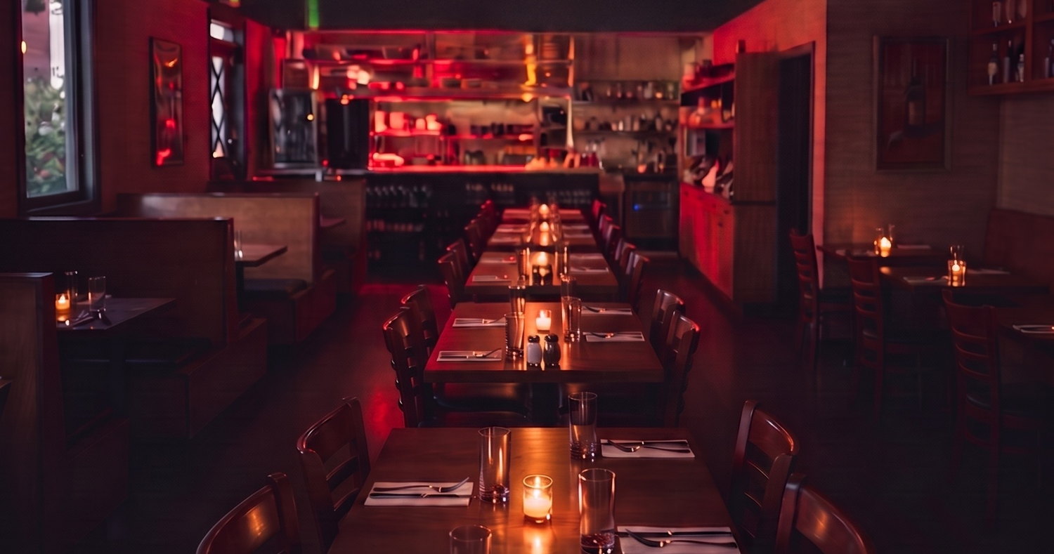 The dining room at night, candles lit down the tables